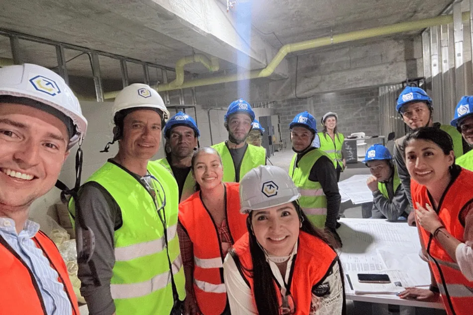 Equipo multidisciplinar de [NOMBRE EMPRESA] revisando planos en obra.